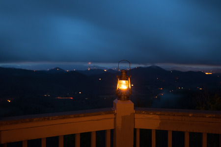 Retro style lantern over night mountain backgroundの写真素材