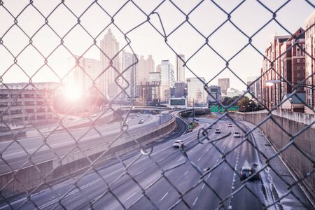 Morning city skyline through the wire mesh fence. Sunrise Atlanta cityscape, Georgia, USAの写真素材