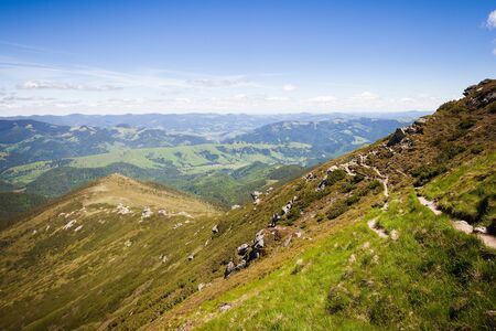 Summer mountain landscape with man standing on the rocky hillの写真素材