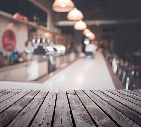 Wooden table top surface over blur cafe background