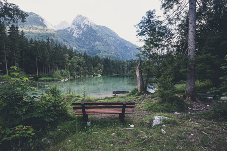 Empty bench near alpine mountain lakeの写真素材