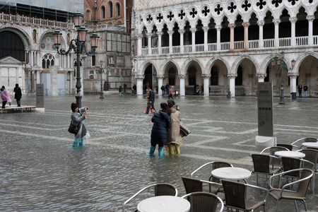 VENICE, ITALY - NOVEMBER 07, 2017: Tourists walking along flooding Piazza San Marco in Veniceの写真素材