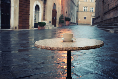 Cup of coffee on the old european city street cafe tableの写真素材