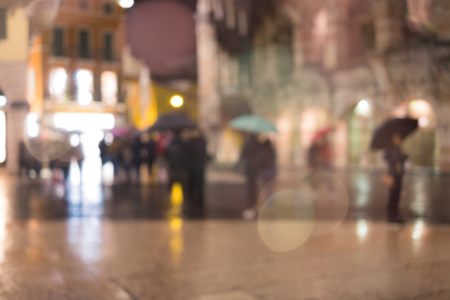 Illuminated old European street at rainy night. Abstract blurred bokeh lights backgroundの写真素材