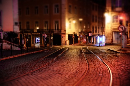 Illuminated street of old european town at night. Tilt-shift effect