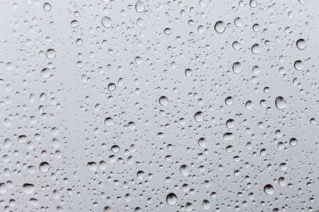 Drops of rain on a window glass. Through the window view of overcast cloudsの写真素材