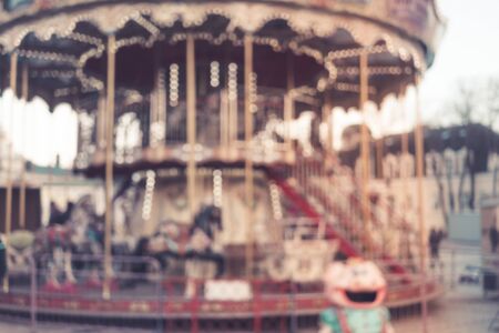 Image of blur street with festive lights and carousel in night time. Blur bokeh light defocused backgroundの写真素材