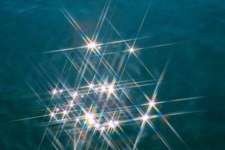 Glare on the water in the form of stars. Natural abstract sea water background.の写真素材
