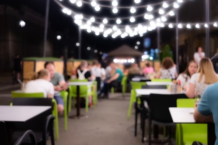 Abstract blurred image of night festival in a restaurant. Happy and relaxing people at the cafe...