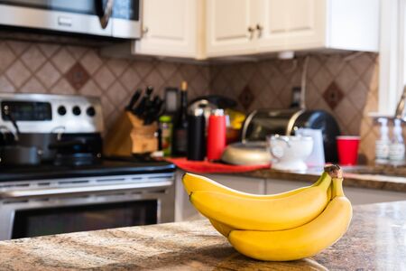 Interior of a kitchen with a bunch of bananas on the foregroundの写真素材