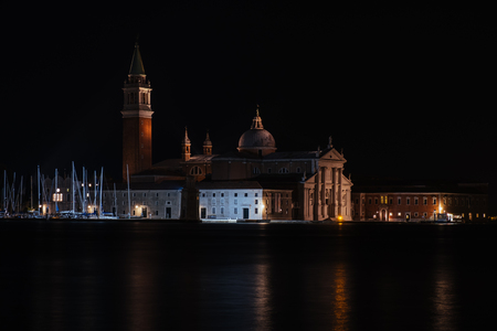 Venice canal with historical buildings and gondolas at night. Italy.のeditorial素材
