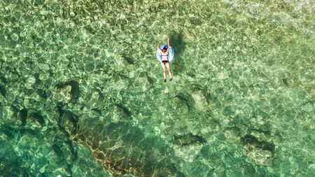 Beautiful young woman with inflatable ring relaxing in the sea.の写真素材