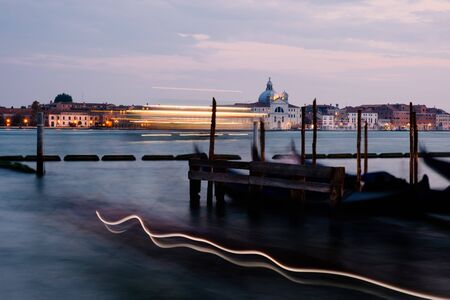 Evening view of gondolas on the wave and San Giorgio Maggiore, Venice, Italyの写真素材