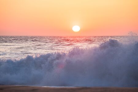 Sunrise and shining waves in ocean. Tropical beach panoramaの写真素材