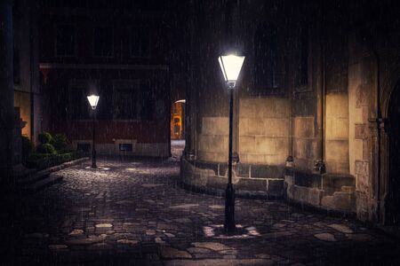 Rainy night in old European city with lanternsの写真素材