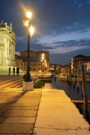 Venice canal with historical buildings and gondolas at night. Italy.の写真素材