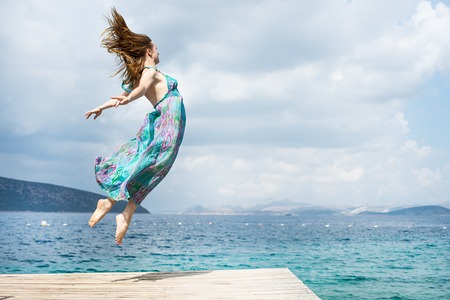 Young woman jumping on the beachの写真素材