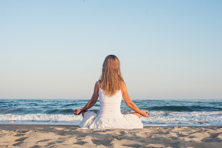 Woman meditating at the seaの写真素材