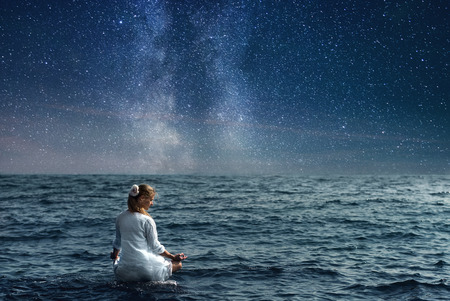Woman meditating at the seaの写真素材