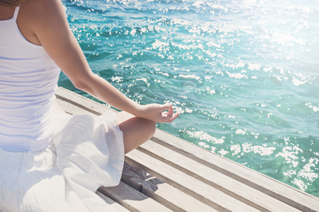 Woman meditating at the seaの写真素材