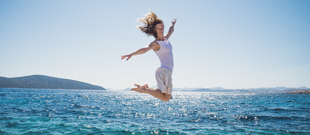 Young woman jumping on the beachの写真素材