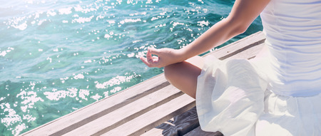 Woman meditating at the seaの写真素材