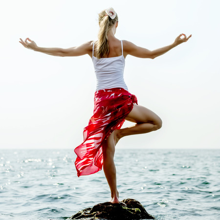 Woman meditating at the seaの写真素材