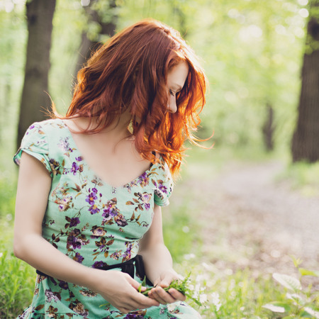 Girl sitting in the flower fieldの写真素材
