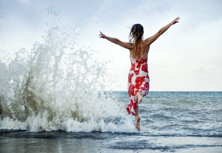 Woman jumping on the beachの写真素材