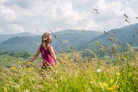 Blonde Woman staying at the Mountains at sunny dayの写真素材