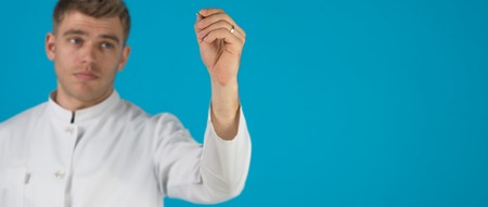 Portrait Of A Doctor with pen Isolated On Blue Backgroundの写真素材