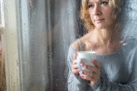 Young woman with cup throw the rain drops