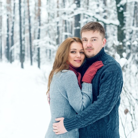 Portrait of happy young woman and her boyfriend in winter parkの写真素材