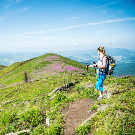 Young woman with backpack hiking in the mountainsの写真素材
