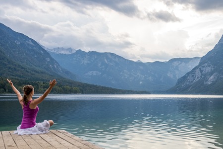 Woman meditating at the lakeの写真素材