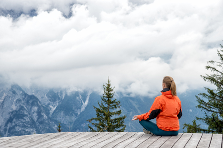 young woman on top of the mountain meditateの写真素材
