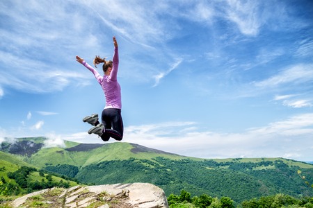 Young woman jumping in the mountainsの写真素材