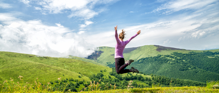 Young woman jumping in the mountainsの写真素材