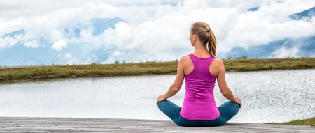 young woman on top of the mountain meditateの写真素材