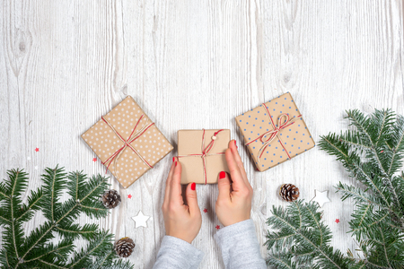 Gift box in hands with Christmas backgroundの写真素材