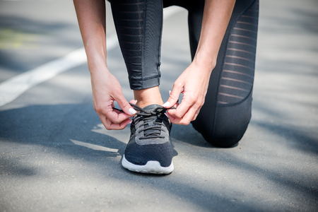 Young beautiful sportive girl preparing to run in the parkの写真素材