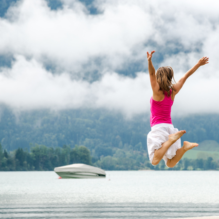 Woman jumping at the lake