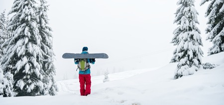 snowboarder girl standing with snowboard,の写真素材