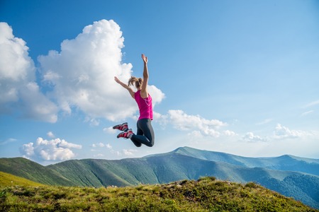Young woman jumping in the mountainsの写真素材