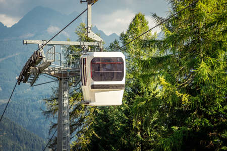 gondola ski lift in mountain ski resort, green forest