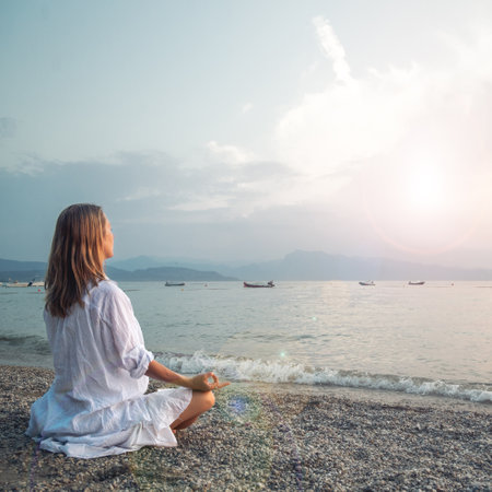 Woman meditating at the Garda Lake. Sunset.の写真素材