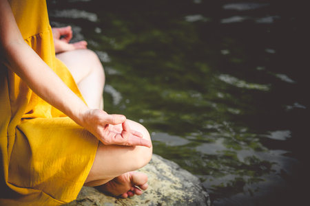 Woman doing yoga on the stone at the mountain river. Carpathiansの写真素材