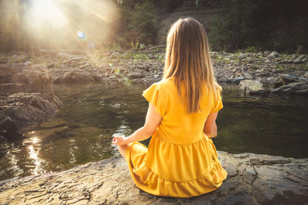 Woman doing yoga on the stone at the mountain river. Carpathiansの写真素材