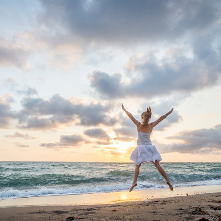 Happy beautiful young girl jumpingの写真素材