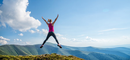 Young woman jumping in the mountainsの写真素材